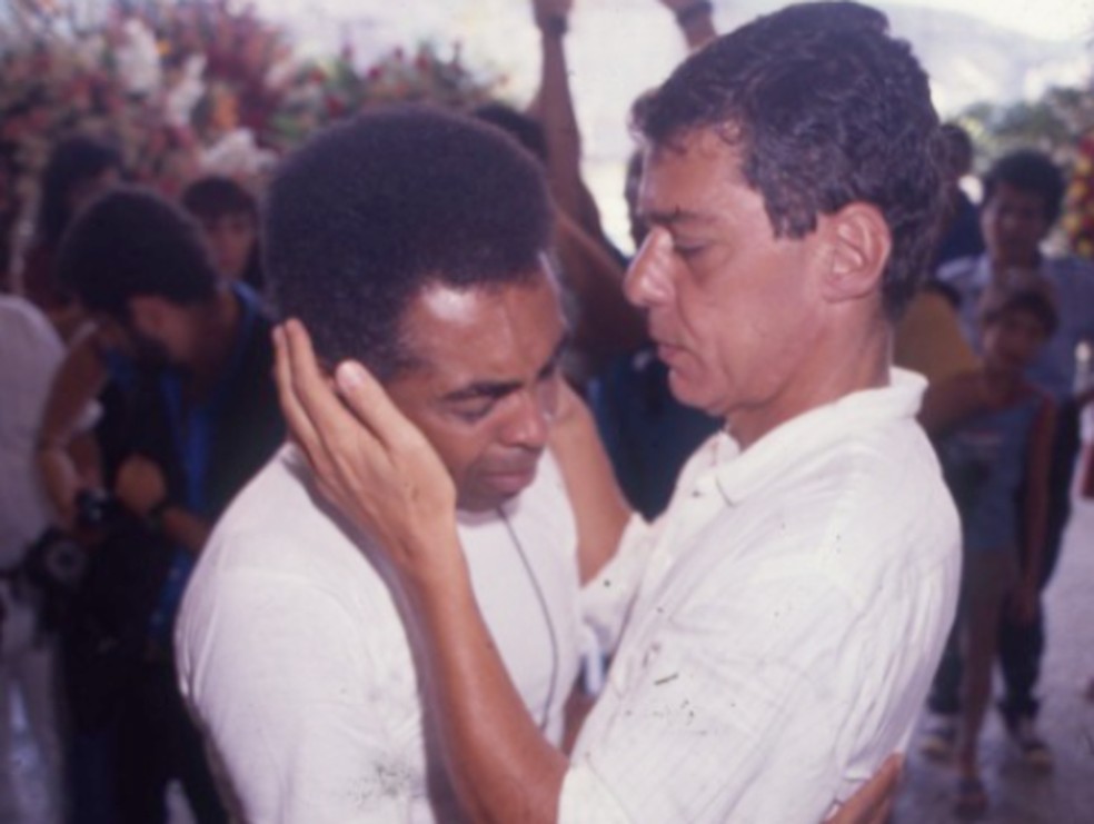 Gilberto Gil consolado por Chico Buarque no velório do filho Pedro, em 1990 — Foto: Guilherme Bastos/Agência O GLOBO