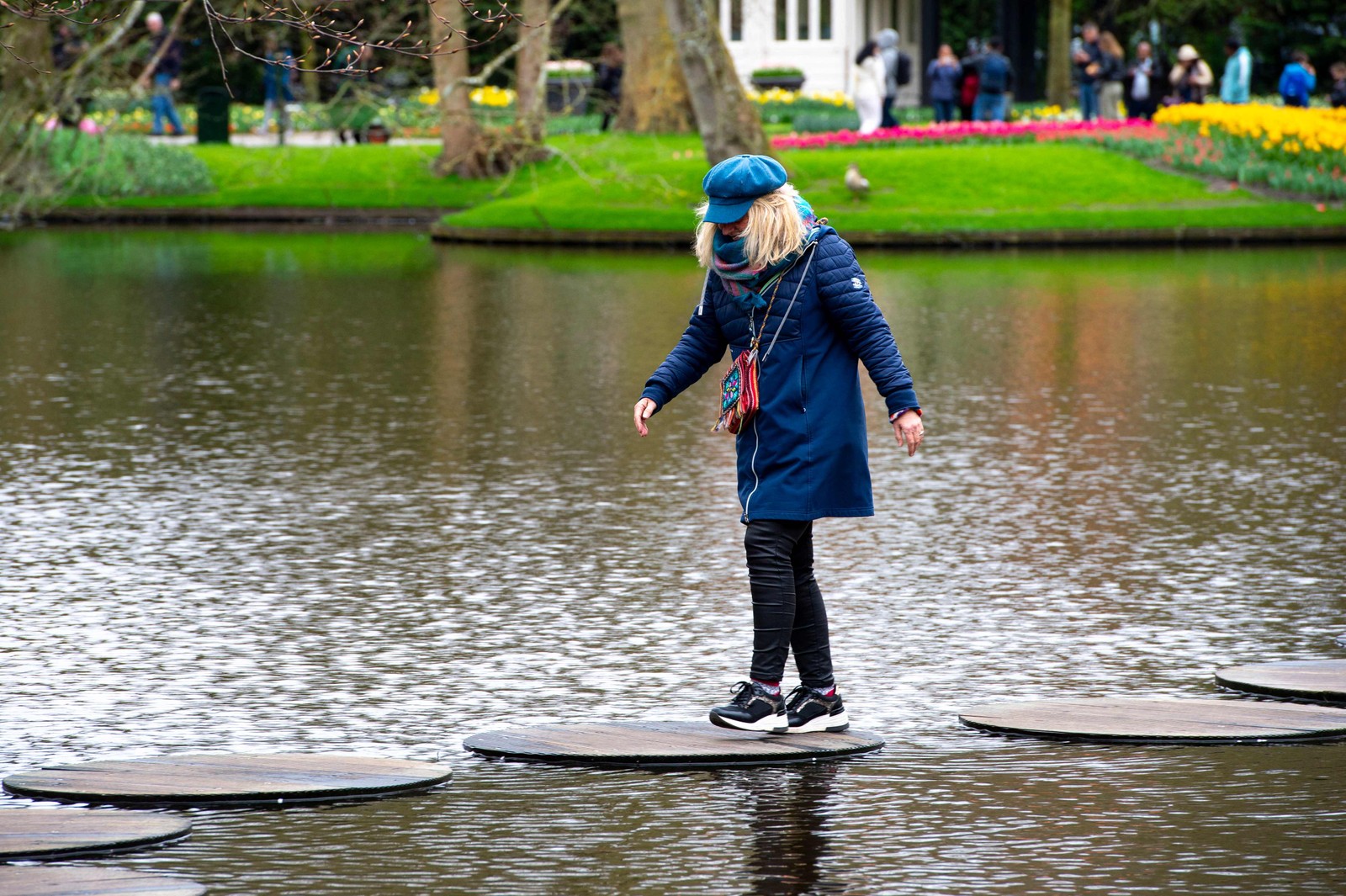 Visitors walk along the lake path at Keukenhof Gardens in Lisse, near Amsterdam, Netherlands — Photo: Nick Gammon/AFP