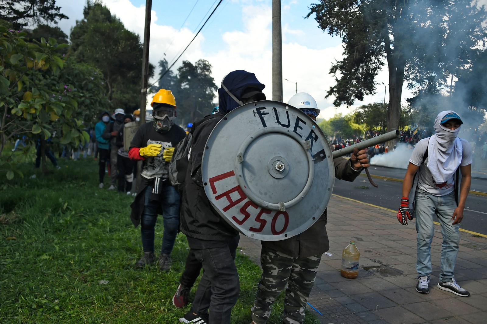 Manifestantes entram em confronto com a polícia com um escudo improvisado onde se lê "Fora Lasso", referindo-se ao presidente equatoriano Guillermo Lasso, no parque El Arbolito, em Quito — Foto: RODRIGO BUENDIA / AFP