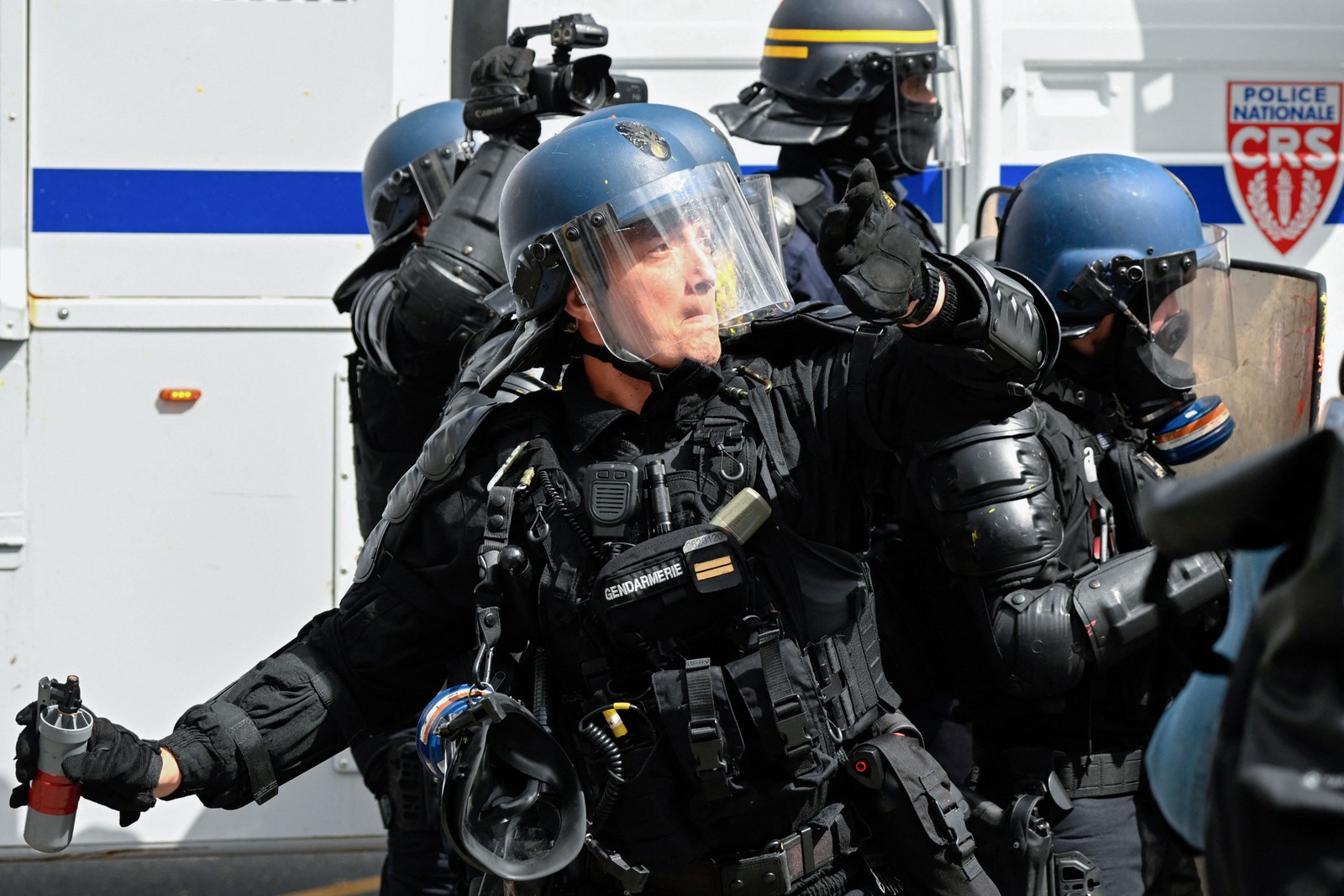 Policial francês lança uma granada de gás lacrimogêneo contra manifestantes durante protesto em Rennes — Foto: Damien MEYER / AFP