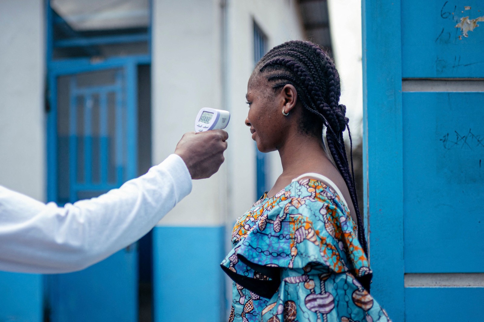 Uma funcion&aacute;ria verifica a temperatura de uma antes de permitir seu acesso ao hospital em Goma &mdash; Foto: Jospin Mwisha / AFP