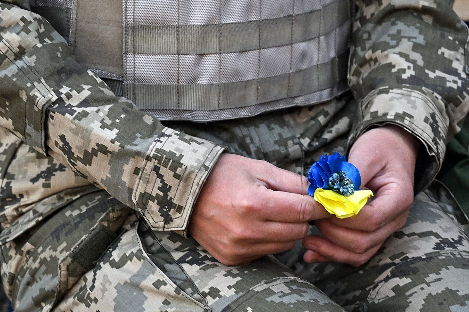 Cadete ucraniana segura uma flor artificial na cor da bandeira do seu país — Foto: Sergei SUPINSKY / AFP