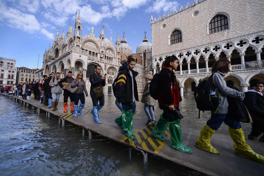 Turistas caminham por uma passarela numa inundada Praça São Marco, em Veneza: cidade italiana decidiu testar a taxa 5 euros para visitantes de um dia em 2024