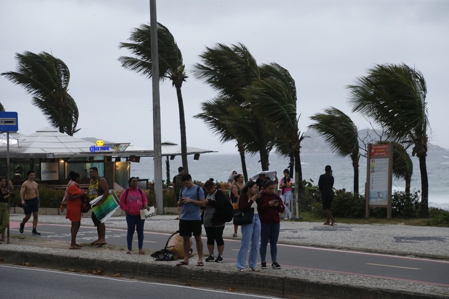 Pessoas no ponto de ônibus na Avenida Lucio Costa