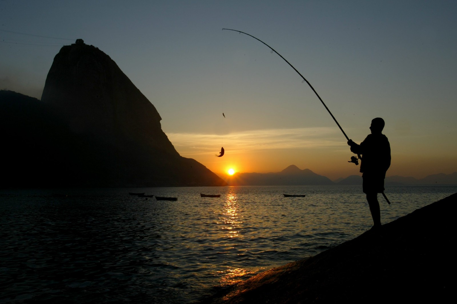 A visão privilegiada de quem acorda cedo para pescar na Baía de Guanabara — Foto: Custodio Coimbra/Agência O Globo