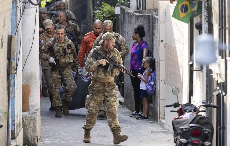 Policiais carregam corpo de suspeito morto durante opera&ccedil;&atilde;o na Ladeira dos Tabajaras, no Rio