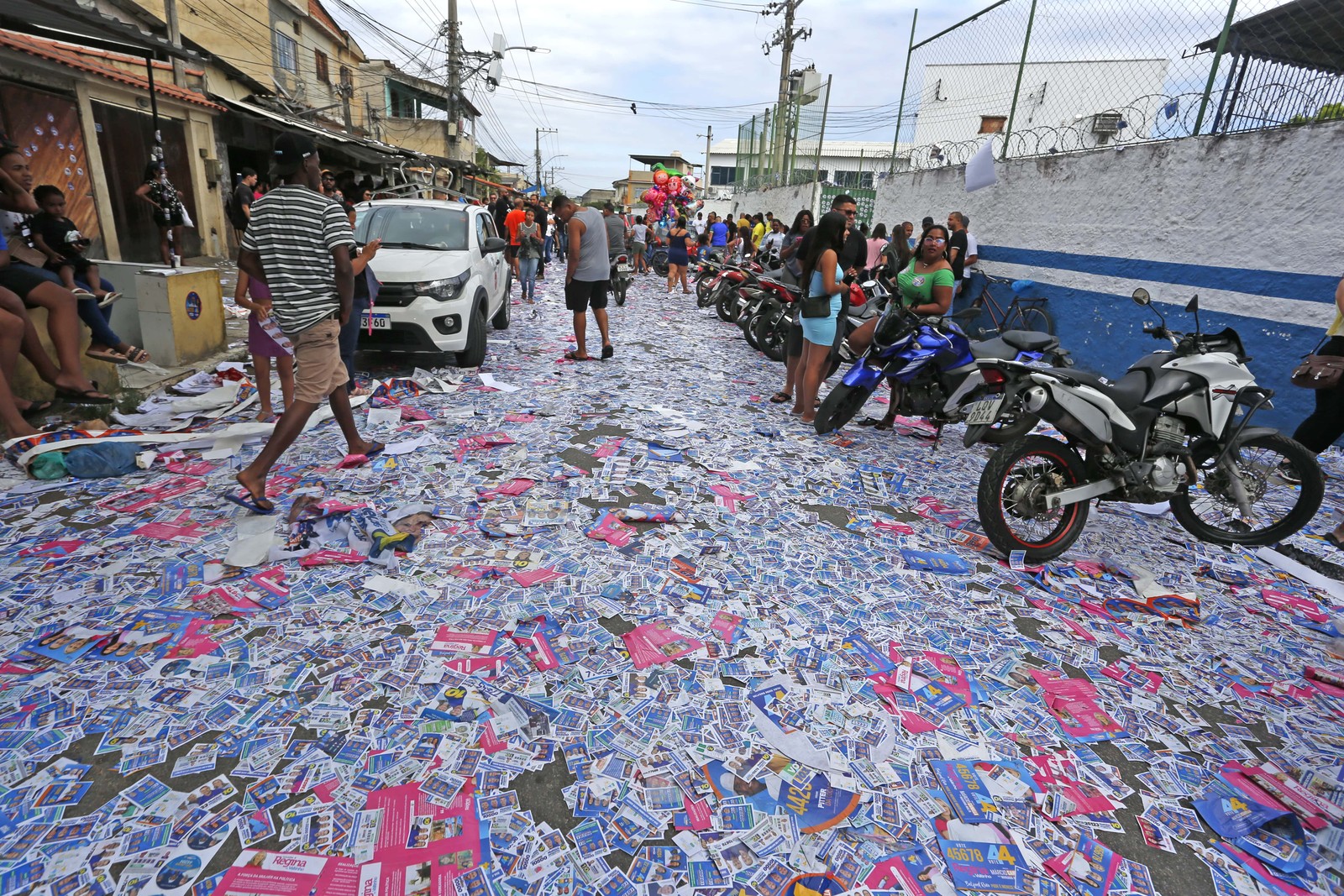 Santinhos enchem rua próxima ao Colégio Estadual Presidente Kennedy, em Belford Roxo, na Baixada Fluminense — Foto: Fabiano Rocha / Agência O Globo