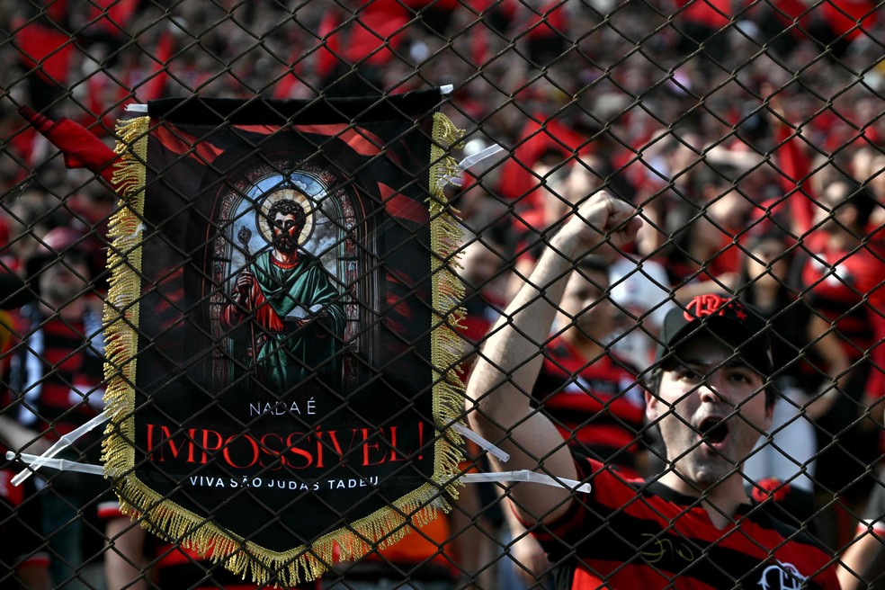 A Flamengo fan holds a picture of São Judas Tadeo in Lima – Photograph: Luis ACOSTA / AFP