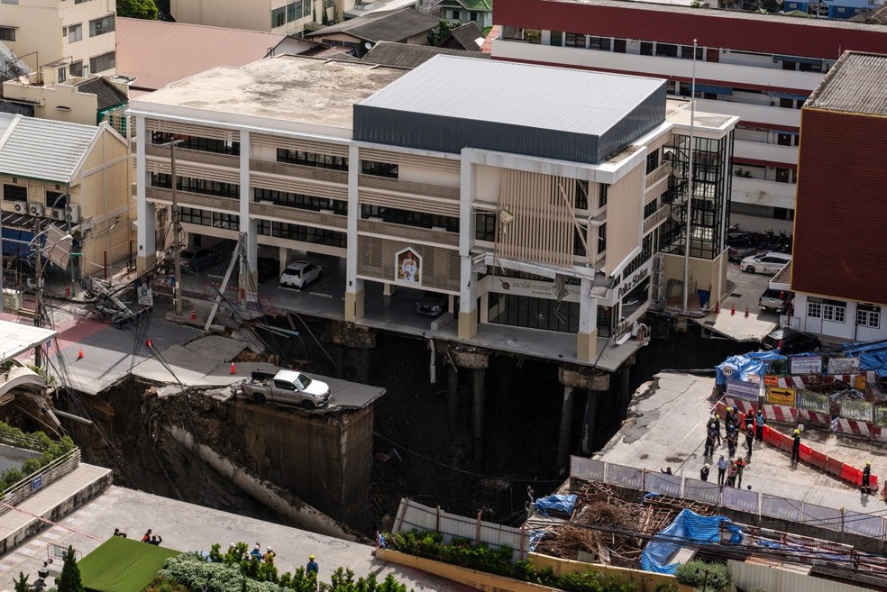 Cratera gigante engole rua em Bangcoc após colapso em obra de metrô — Foto: AFP
