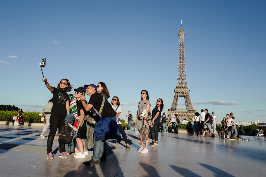 Turistas em frente à Torre Eiffel, em Paris
