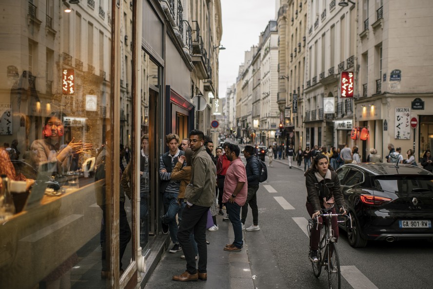 Sem máscaras nem distanciamento, pessoas aguardam na fila do lado de fora de restaurante em Paris
