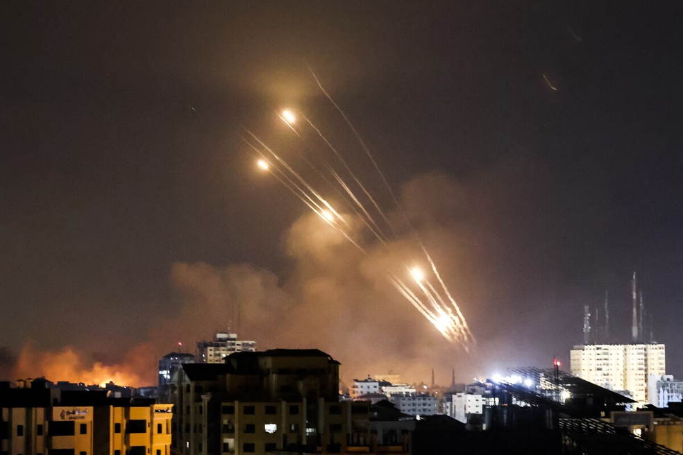 Uma salva de foguetes é disparada por combatentes palestinos do Hamas em direção a Israel — Foto: MOHAMMED ABED / AFP