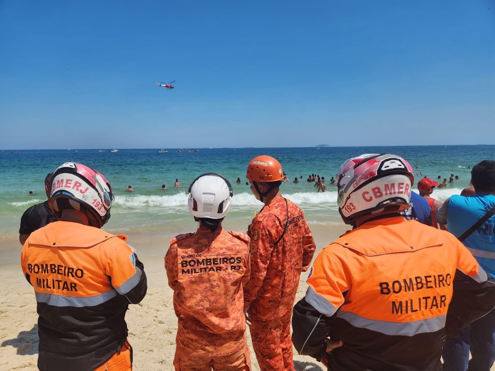 Homens do Corpo de Bombeiros acompanham o resgate — Foto: Custódio Coimbra/Agência O Globo