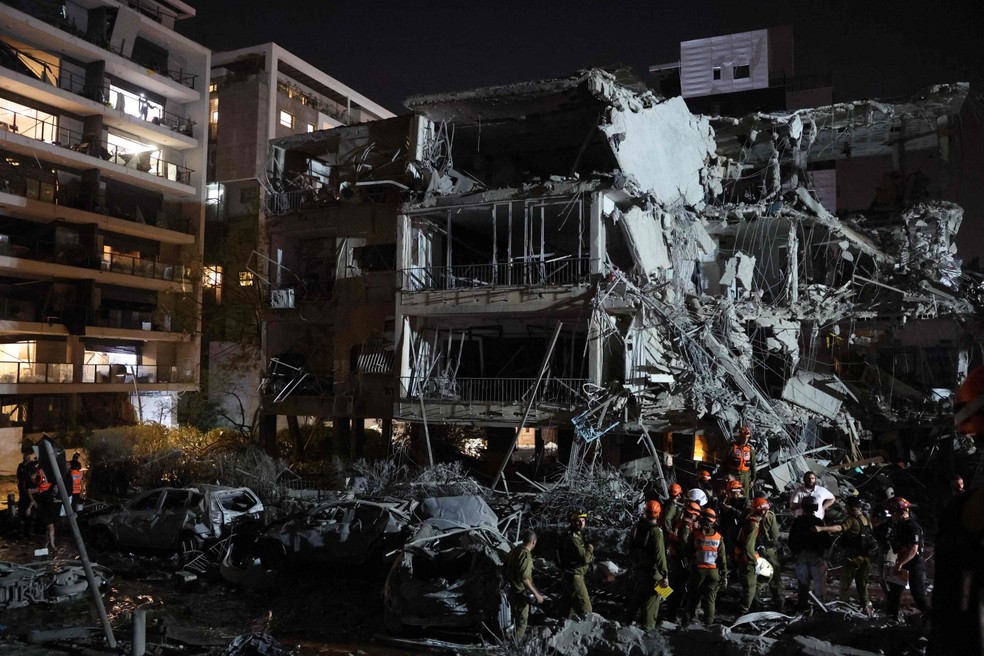 Socorristas buscam feridos após míssil do Irã atingir prédio em Tel Aviv — Foto: Gil COHEN-MAGEN / AFP