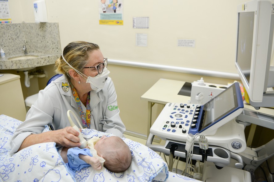 Médica Cristiane Binotto realiza o exame em bebê paciente do Hospital Pequeno Príncipe, em Curitiba: identificação de casos aumentou, mas o acesso a serviços ainda é um desafio