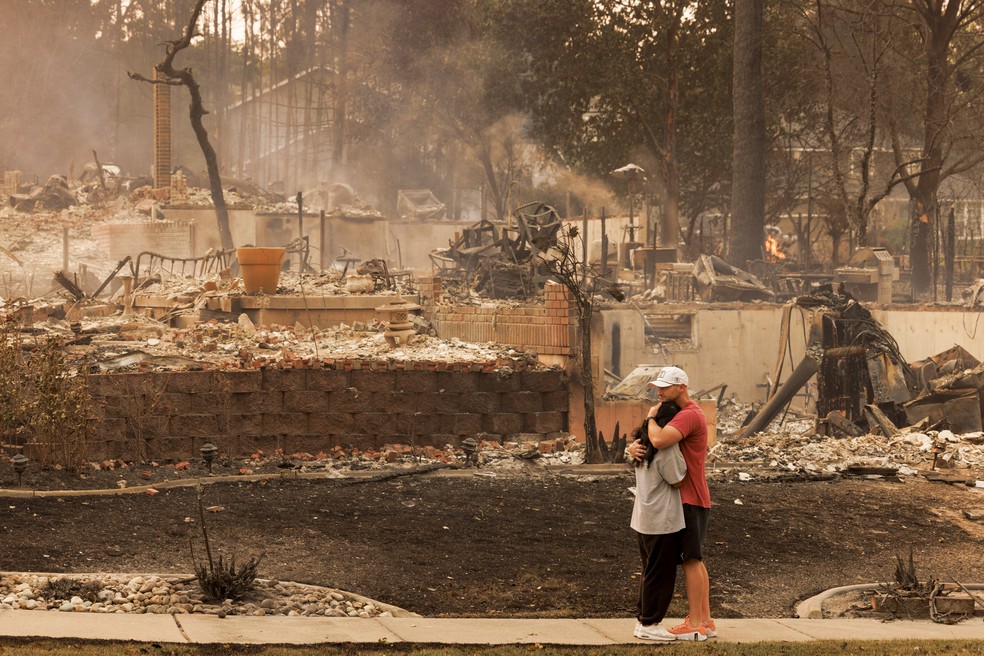 Christine e Bryan Farris se abraçam após terem perdido todos os seus pertences no incêndio florestal Old Trail, em Spokane, Washington, no domingo, 2 de agosto de 2026 — Foto: John Stember / The New York Times