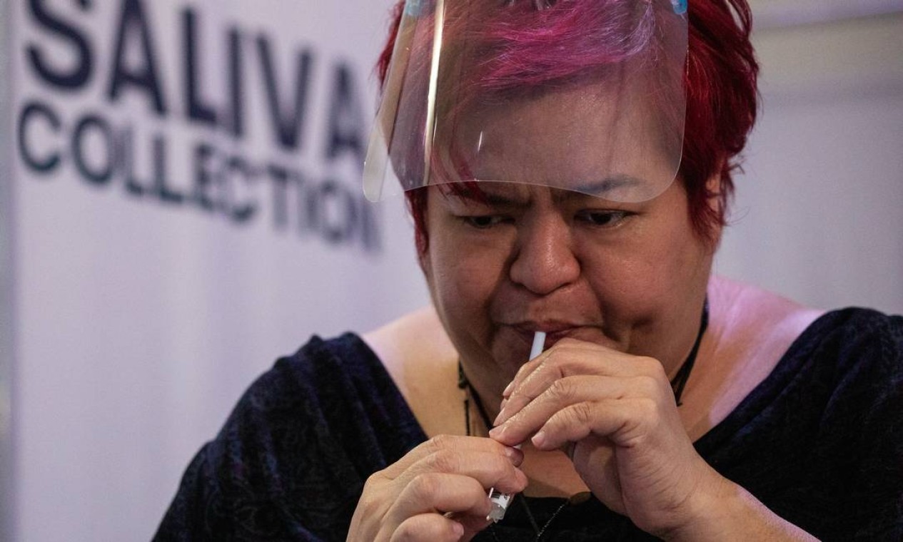 Mulher transfere saliva para um frasco para teste de saliva de doença coronavírus (COVID-19), em um laboratório molecular da Cruz Vermelha Filipina, na cidade de Mandaluyong, Metro Manila — Foto: ELOISA LOPEZ / REUTERS