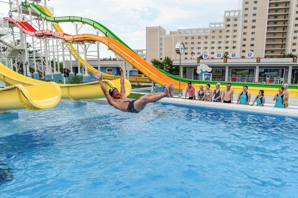 Homem desce em toboágua em parque aquático no resort de Wonsan Kalma, na Coreia do Norte — Foto: KIM Won Jin / AFP