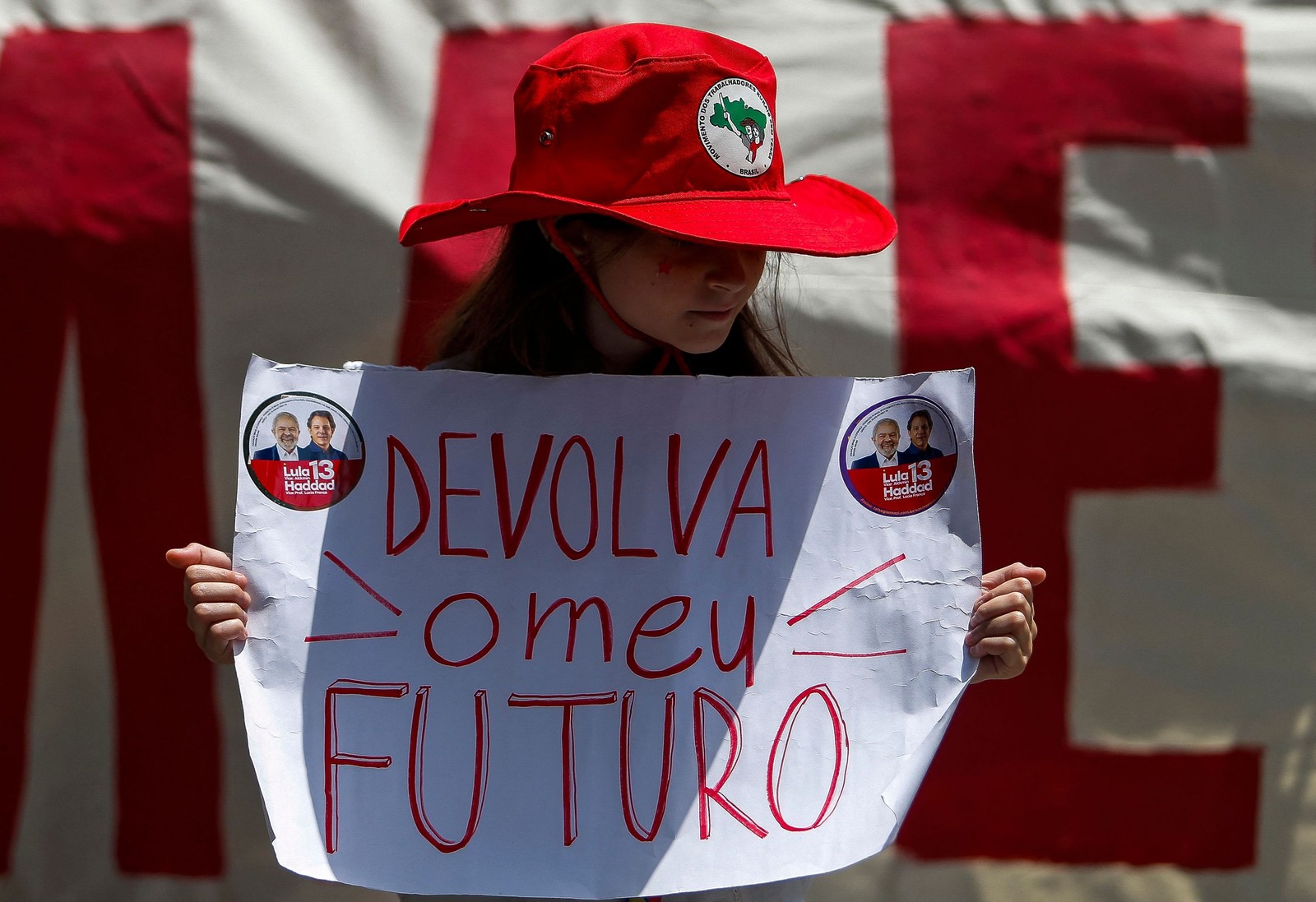 Menina segura cartaz com a frase "Devolva meu futuro" durante ato de campanha em São Paulo. — Foto: Miguel SCHINCARIOL / AFP