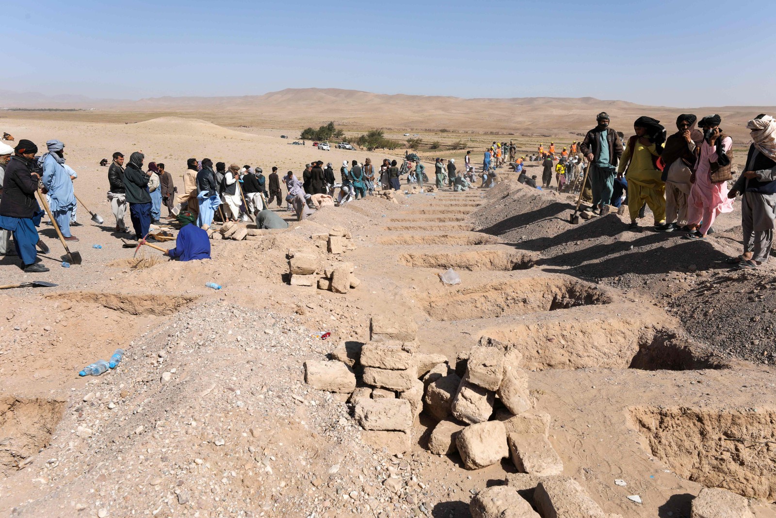 Afeg&atilde;os cavam sepulturas para os corpos das v&iacute;timas dos terremotos na vila de Sarbuland, distrito de Zendeh Jan, na prov&iacute;ncia de Herat, em 8 de outubro de 2023 &mdash; Foto: Mohsen KARIMI / AFP