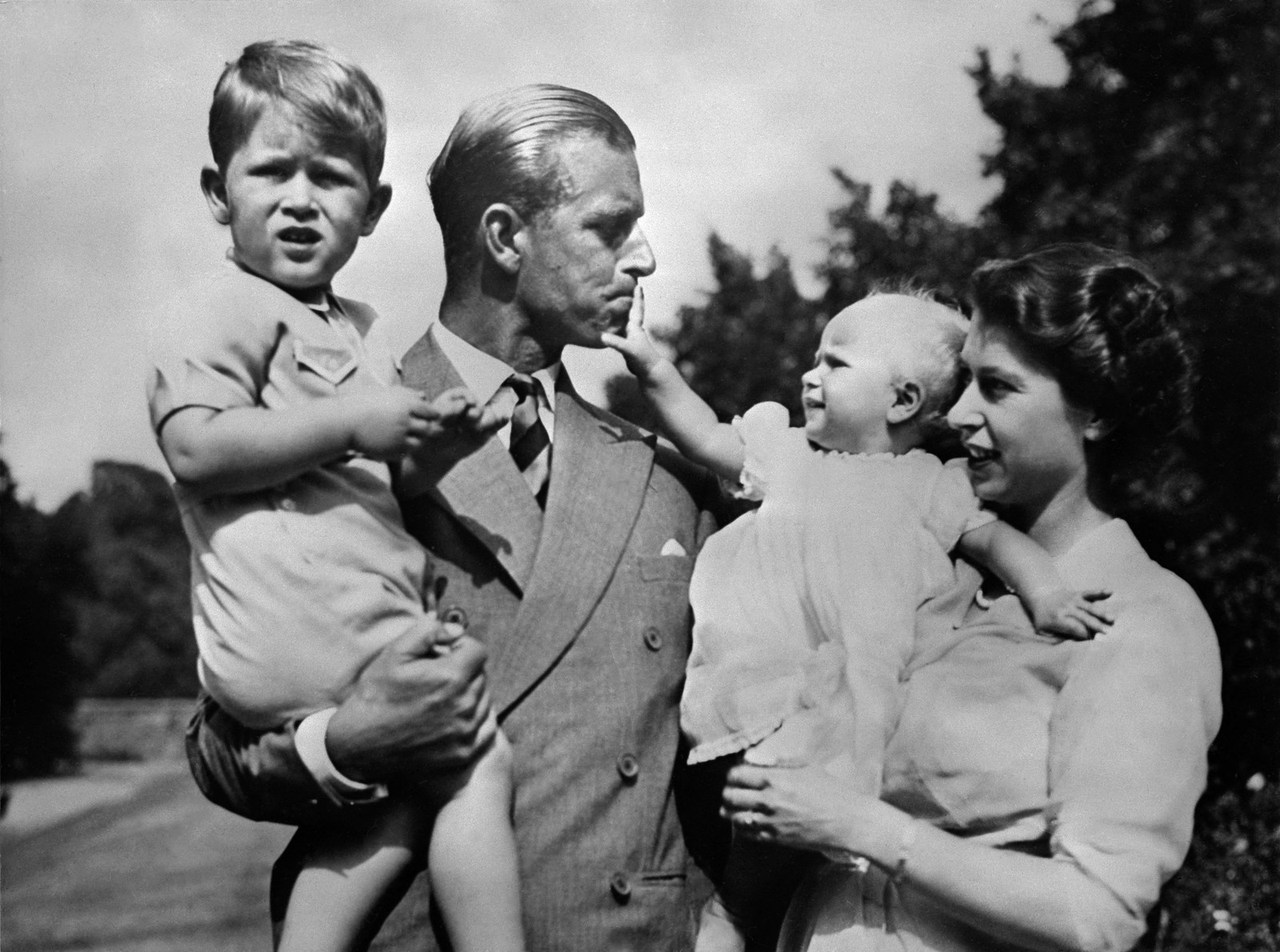 A rainha Elizabeth II e seu marido, o príncipe Philip, duque de Edimburgo, posam com seus dois filhos, Charles, príncipe de Gales (à esquerda) e a princesa Anne  — Foto: AFP