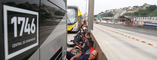 Passageiros e motoristas tentam se proteger durante intenso tiroteio em favelas do Complexo de Israel, próximo à Avenida Brasil — Foto: Fabiano Rocha / Agência O Globo
