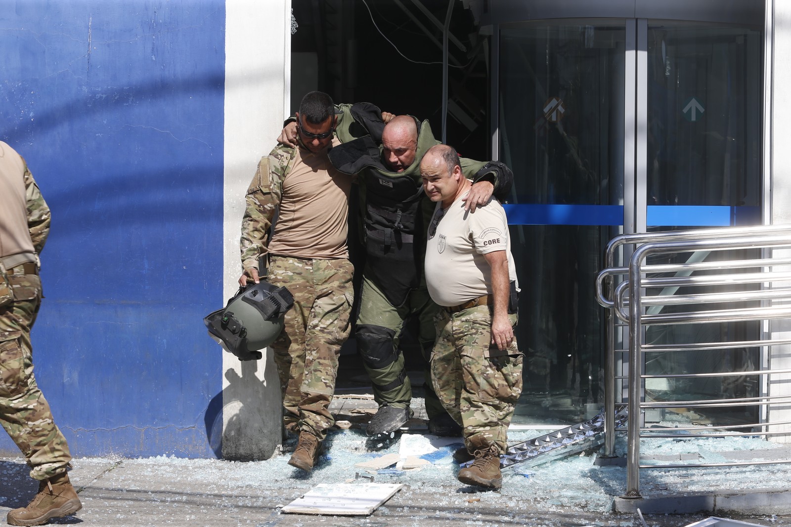 Bomba remanescente explodiu durante operação anti-bomba; agente é socorrido por colegas — Foto: Fabiano Rocha/Agência O Globo
