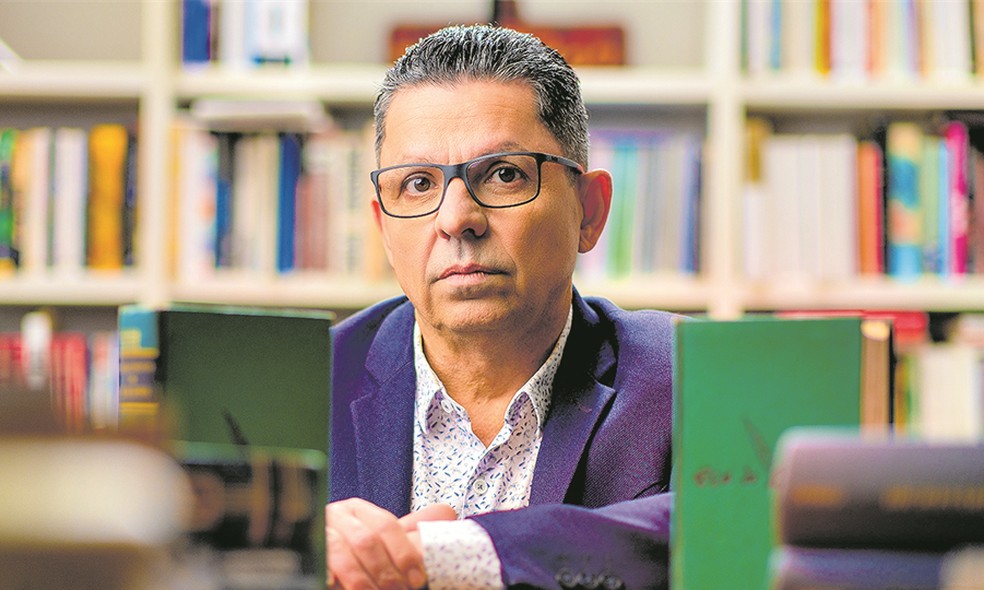 O escritor Miguel Sanches Neto e sua biblioteca — Foto: Divulgação