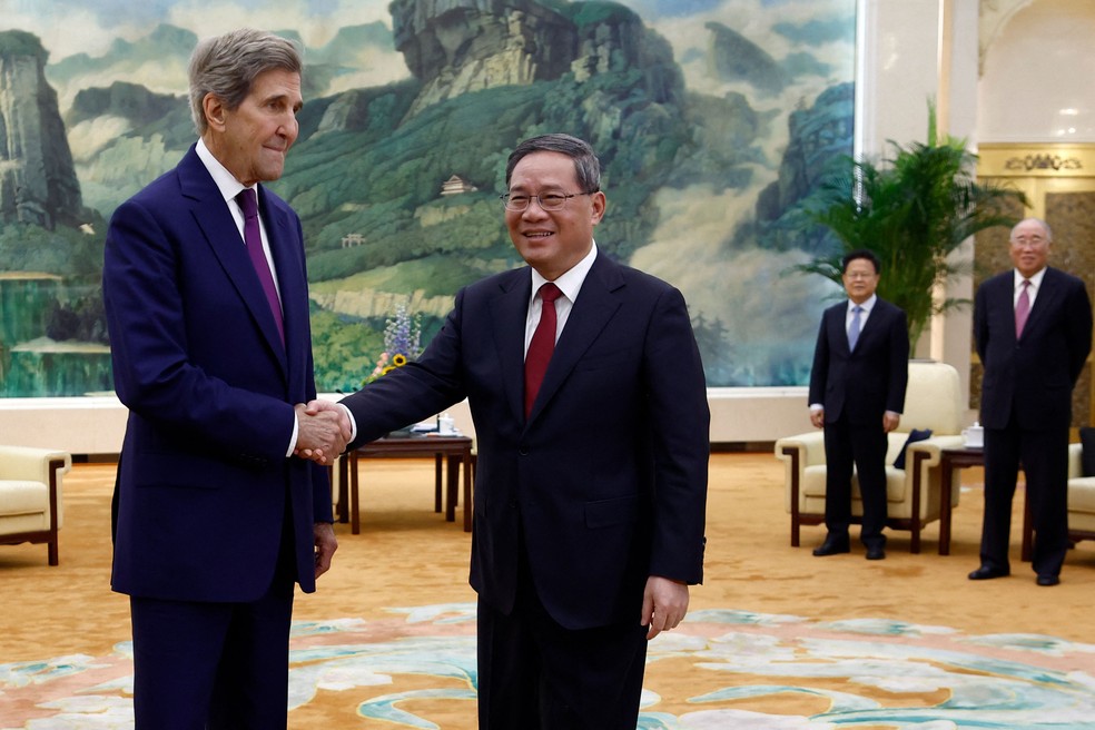 John Kerry aperta a mão de premier chinês, Li Qiang. — Foto: Florence Lo/AFP