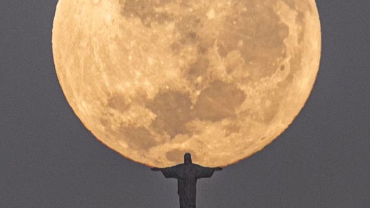 Fotógrafo viraliza com registro do Cristo Redentor 'abraçando' Lua cheia no Rio