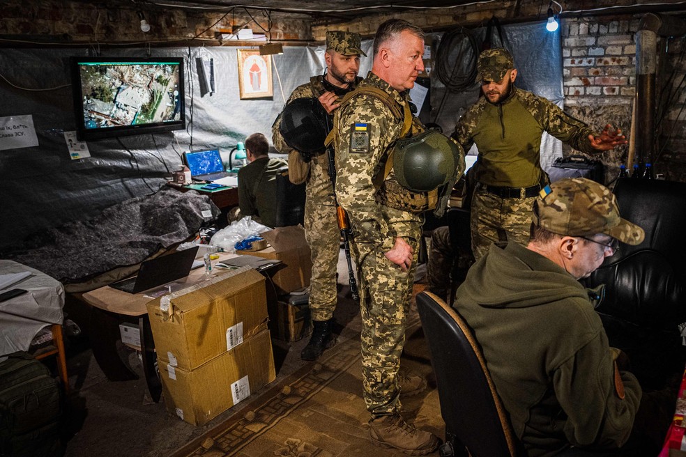 Integrantes da Guarda de Fronteiras da Ucrânia observam imagens feitas por drones na região de Donetsk — Foto: Dimitar DILKOFF / AFP