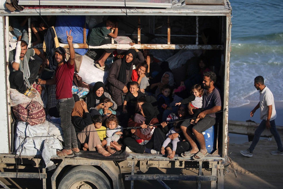 Famílias palestinas se retiram como podem de áreas de conflito — Foto: Eyad Baba/AFP