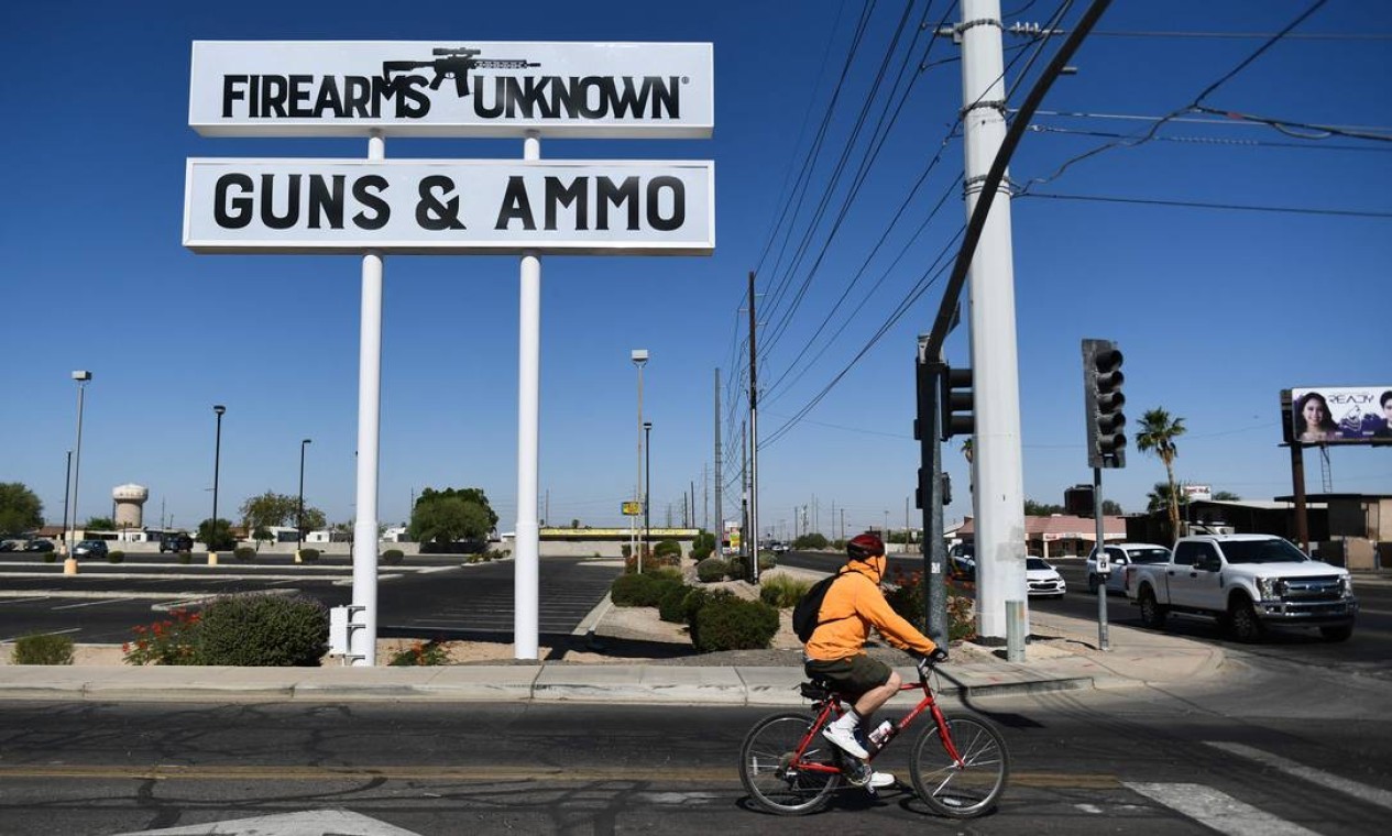Silhueta do rifle AR-15 de silhueta é exibido no letreiro de loja de armas em Yuma, Arizona. O presidente dos EUA, Joe Biden pediu aos legisladores que proíbam armas de assalto a cidadãos comuns — Foto: PATRICK T. FALLON / AFP