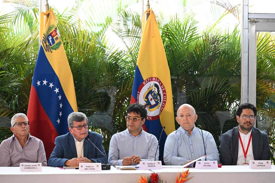 Os comandantes guerrilheiros do Exército de Libertação Nacional (ELN) da Colómbia Aureliano Carbonell (E) e Pablo Beltrán (2-E) se reúnem com os membros da delegação do governo colombiano Danilo Rueda (C), Otty Patino (2-D) e Iván Cepeda (D) durante as negociações de paz concluídas em Caracas