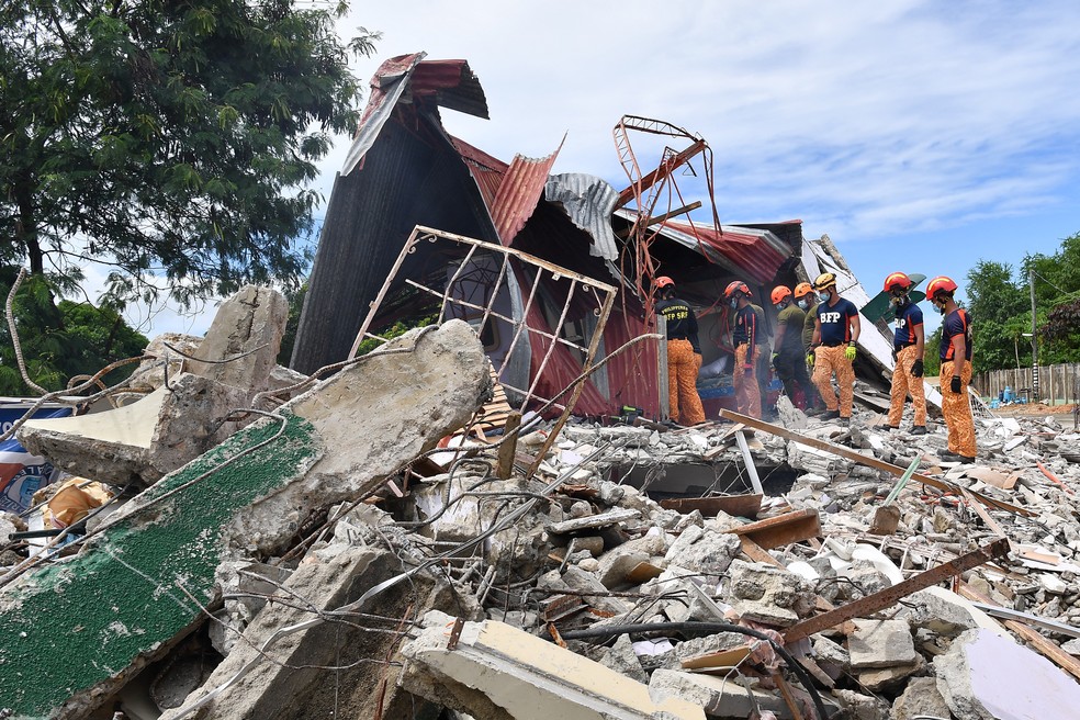 Equipes de resgate procuram por três pessoas que estavam desaparecidas sob os escombros de um prédio que desabou na cidade de Bogo — Foto: Ted ALJIBE / AFP
