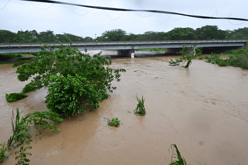 Rio Cobre transbordou perto de Saint Catherine, na jamaica, nesta terça-feira, quando o furacão Melissa atingiu o país — Foto: Ricardo Makyn/AFP