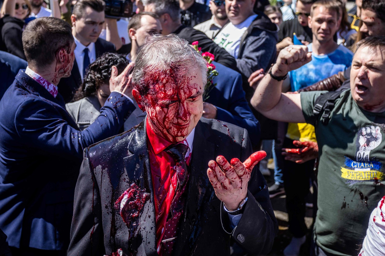 O embaixador russo na Polônia, Sergey Andreev, coberto com tinta vermelha durante um protesto em Varsóvia, Polônia, em 9 de maio — Foto: Wojtek RADWANSKI / AFP