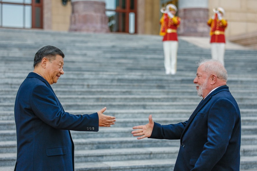 Os presidentes da China, Xi Jinping, e do Brasil, Lula, apertam a mão durante visita oficial