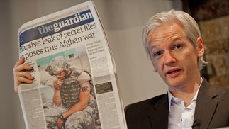 O fundador australiano do site de denúncias 'WikiLeaks', Julian Assange, segura uma cópia do jornal Guardian durante uma conferência de imprensa em Londres, em 2010. para rejeitar a reacção furiosa da Casa Branca às revelações. FOTO — Foto: AFP/Leon Neal