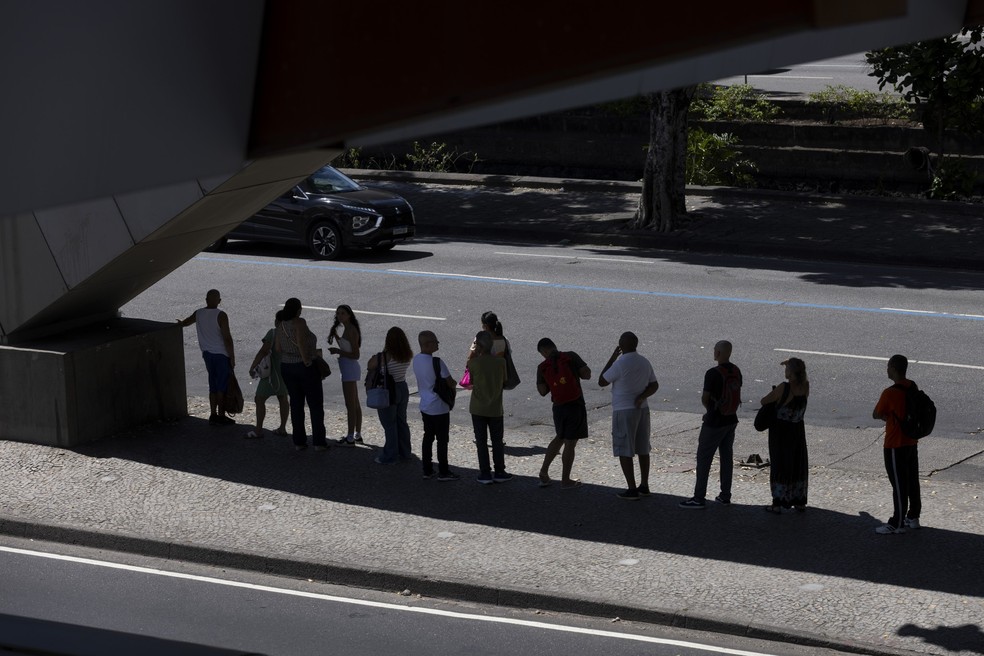 Onda de calor no Rio; pedestres se refrescam em sombra — Foto: Márcia Foletto