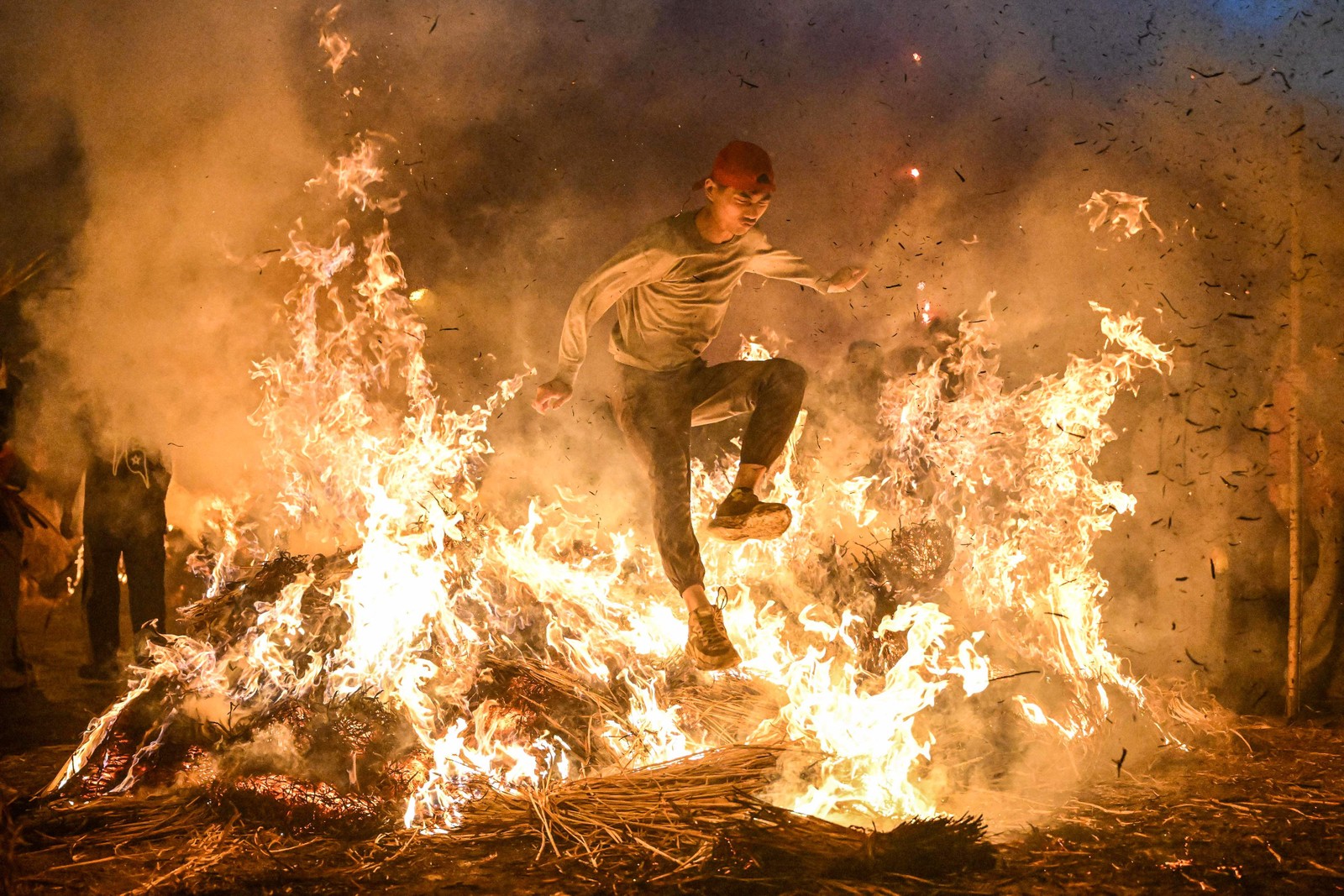 Homem pula fogueira para se livrar da má sorte em Jieyang, na província de Guangdong, no sul da China — Foto: AFP