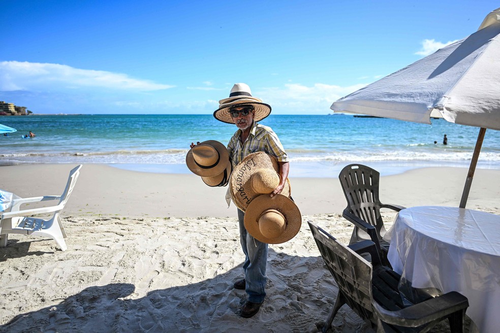 Vendedor de chapéus de palha na Praia de Pampatar, uma das mais conhecidas de Isla Margarita, no Caribe venezuelano — Foto: Juan Barreto / AFP