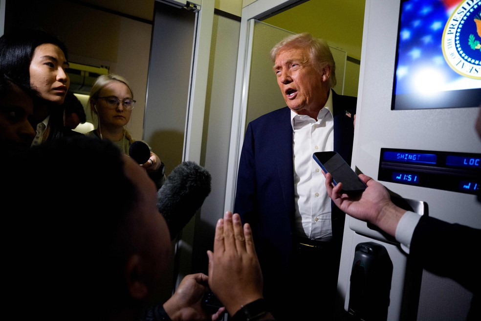 Donald Trump fala com jornalistas a bordo do Air Force 1 a caminho da Malásia — Foto: Andrew Harnik /  Getty Images via AFP