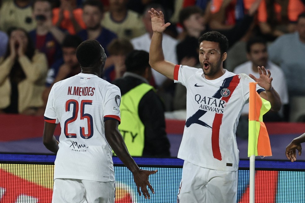 Gonçalo Ramos (à direita) comemora gol da virada do PSG sobre o Barcelona, após bela jogada de Nuno Mendes (à direita) — Foto: Josep Lago/AFP