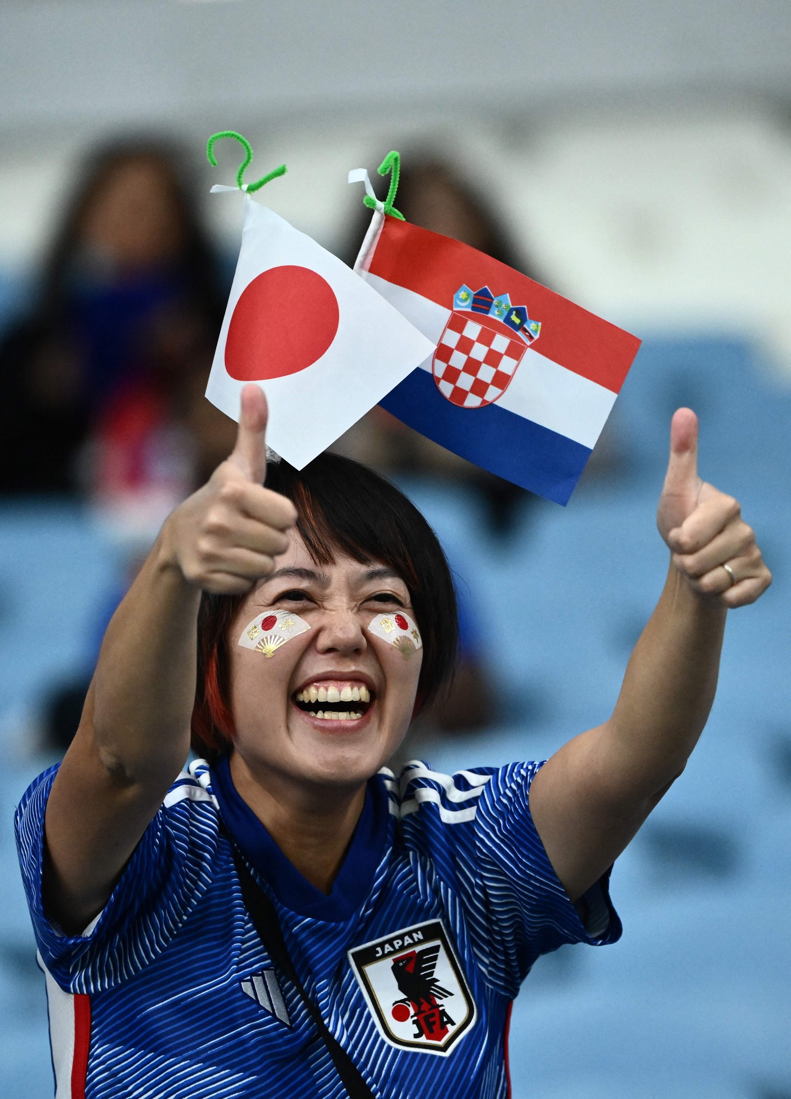 Torcedora do Japão acena antes da partida contra a Croácia — Foto: JEWEL SAMAD/AFP