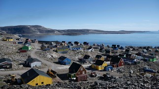 Vila de Ittoqqortoormiit, que tem uma população de aproximadamente 300 habitantes, no fiorde Scoresby Sound, no leste da Groenlândia. O Centro Nacional Francês de Investigação Científica está a realizar uma expedição para explorar os fiordes isolados da Gronelândia, o maior sistema de fiordes do planeta, que permanece muito pouco estudado — Foto: Olivier MORIN / AFP