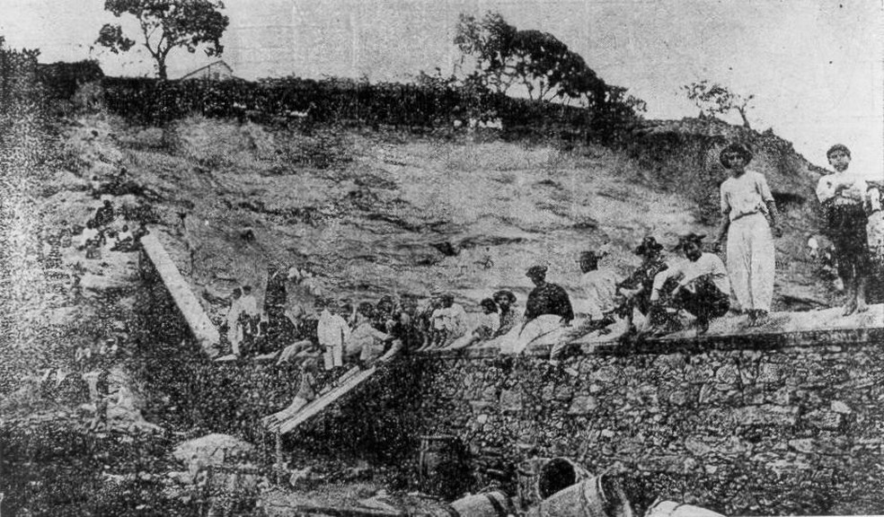 Jovens e trabalhadores negros em cima dos muros em 1905 para assistir a jogo do Fluminense — Foto: Acervo do livro "Footballmania"/Leonardo Pereira