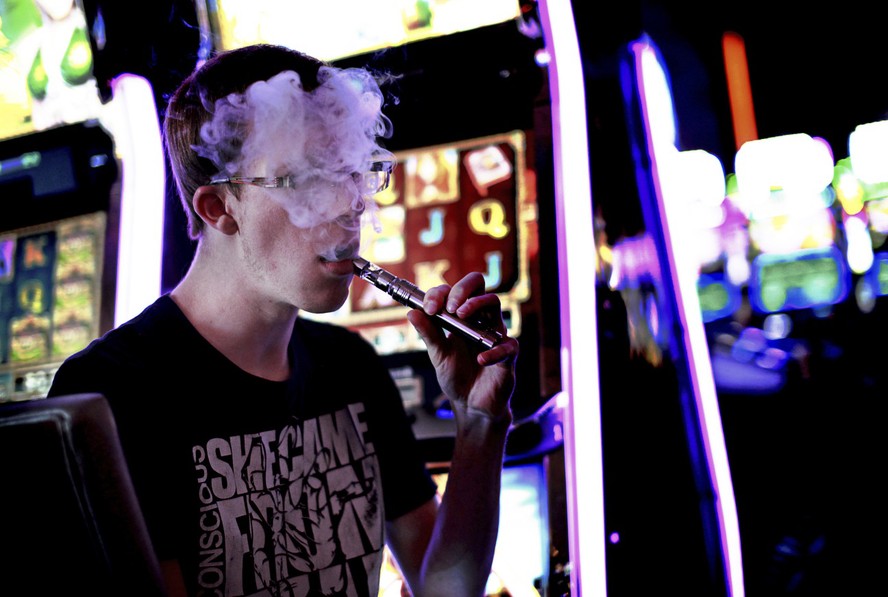 Jovem fuma cigarro eletrônico dentro de um Casino em Las Vegas