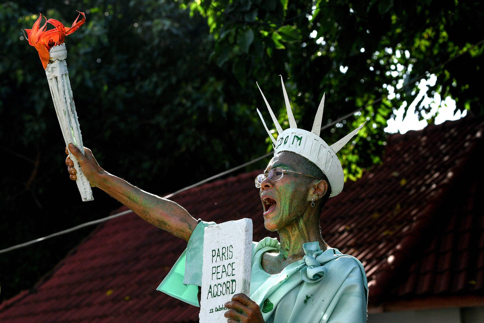 Defensora dos direitos humanos, Theary Seng, veste-se de estátua de liberdade para protestar contra condenação em frente ao tribunal municipal de Phnom Penh, Camboja. Ela, que também é advogada e cidadã dos EUA, faz oposição ao primeiro-ministro Hun Sen, que está no poder desde 1998  — Foto: TANG CHHIN SOTHY / AFP