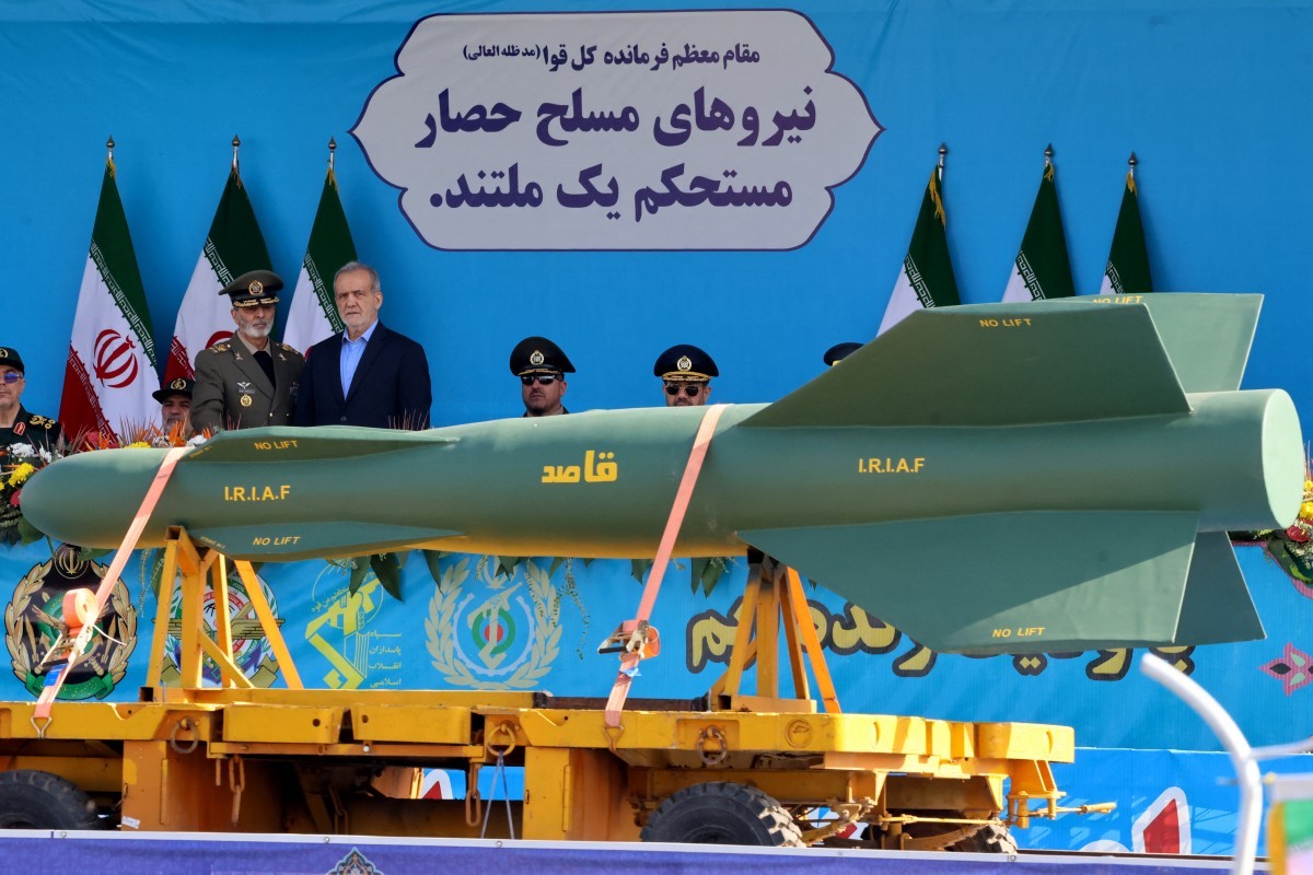 O presidente do Irã, Masoud Pezeshkian, observa enquanto um míssil 'Qased' é exibido durante o desfile militar anual que marca o aniversário da eclosão da guerra de 1980-1988 com o Iraque de Saddam Hussein — Foto: ATTA KENARE / AFP